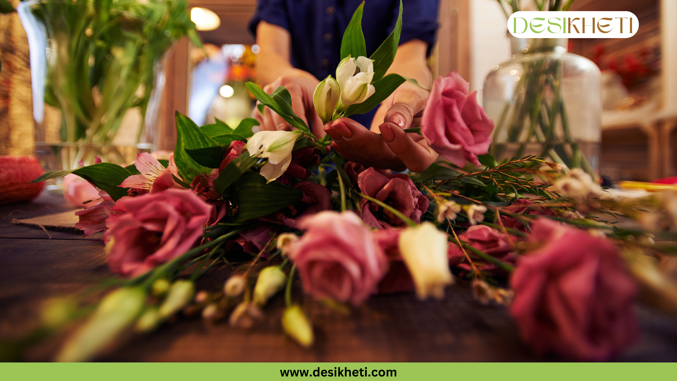 
A person's hands arrange a bouquet of pink and white flowers on a wooden table. The image has a green banner at the bottom with the text "www.desikheti.com" and "DESIKHETI" in the top right corner.